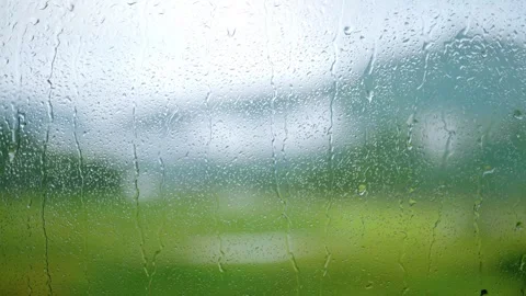 Rain Droplets Cascading Down a Glass Window Pane in Moody Atmospheric Light Stock Footage 341909721