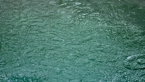 Rain droplets drops falling onto the surface of a swimming pool Stock Footage 276797088