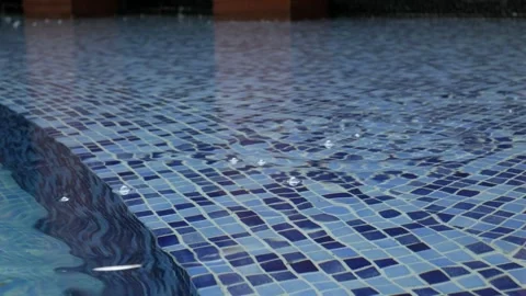 Rain droplets drops falling onto the surface of a swimming pool, Close up r.. Stock Footage 312166559