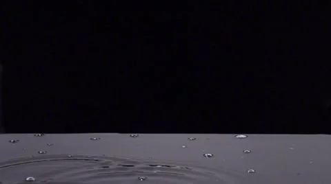 Rain droplets fall sporadically into puddle Video stock 43260051