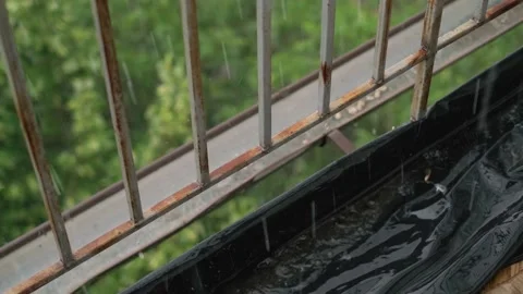 Rain droplets falling on a balcony during a heavy downpour, with an open balcony Video stock 281577013
