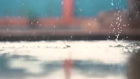 Rain droplets falling on ground on blurred background Stock Footage 140119292