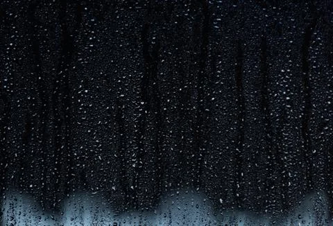 Rain droplets running down a window, abstract backlight background 스톡 사진