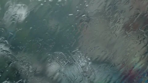 Rain droplets sliding down a car window during a summer storm Stock Footage 342332131