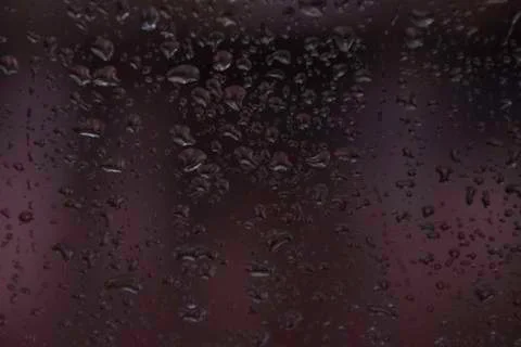 Rain droplets on window with out of focus purple background Stock Photos