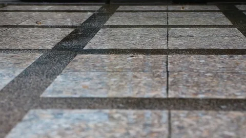 The rain is dropping from the sky onto the concrete floor in the city and mak Stock Footage 82813649