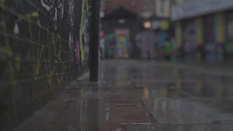 Rain dropping on tiled sidewalk in a suburban area with many graffities Stock Footage 146454983