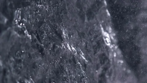 Rain drops and particles falling in super slow motion on a rock during a storm Stock Footage 257320548