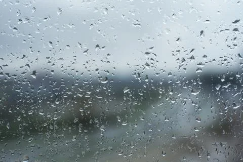 Rain drops are visible on a window glass, creating a textured pattern and a m Stock Photos