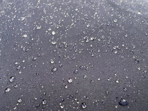 Rain Drops Beading on Water Resistant Dark Navy Textile Macro Stock-Fotos