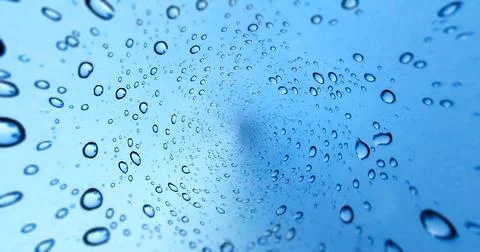 Rain drops on blue glass window background Stock Photos