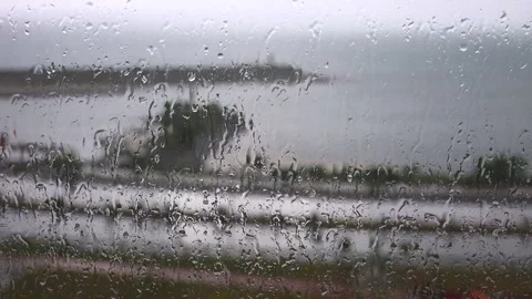 Rain drops blur sea view through misty window glass - Raindrops and Wet Surface Stock Footage 339816306
