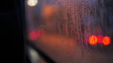Rain Drops on Bus Window Glass with Blurred Night City Car Lights Bokeh as Stock Footage 82674184