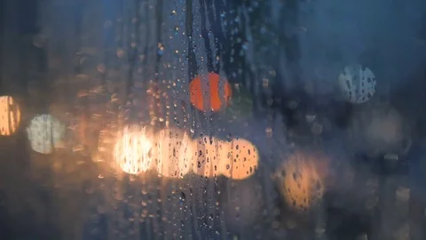 Rain Drops on Car Window Glass with Blurred Night City Car Lights Bokeh as Stock Footage