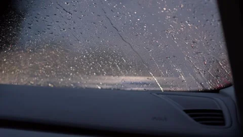 Rain drops on car windshield during rainy evening drive Stock Footage 341766979