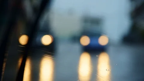 Rain drops on car windshield, view from inside. Street bokeh from moving car. Stock Footage 119985491