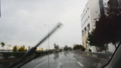 Rain drops on car windshield, view from inside. Street bokeh from moving car Stock Footage 119985821