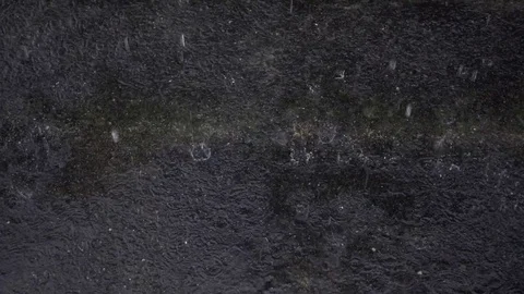 Rain drops dripping on pavement in slow motion shot. Stock Footage 78100189