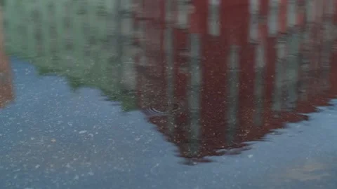Rain drops dripping in a puddle on the road. Heavy water droplets falling on Stock Footage 251730761