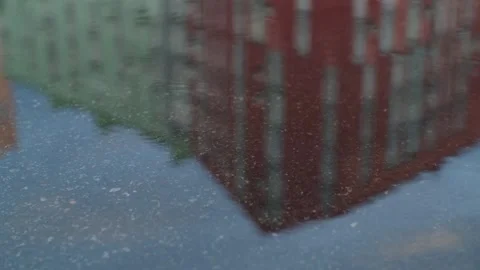Rain drops dripping in puddle on the road. Heavy water droplets falling on Stock Footage 251731117