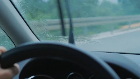 Rain drops on driving car front window, rain-sensing wipers Stock Footage 113619657