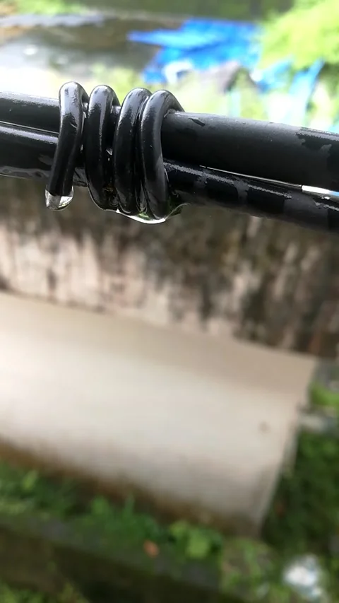 Rain drops dropping from a hanging rope during raining. Stock Footage 134625572