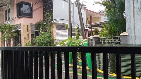 Rain drops fall on concrete and black iron fence Stock Footage 145569616