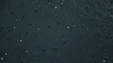Rain drops fall on water surface of pond, lake or river Stock Footage 112484222