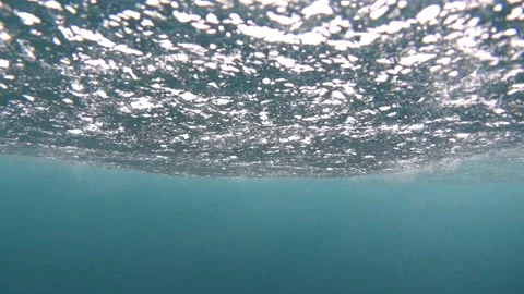 Rain drops fall on the wavy surface of the ocean. Super slow motion Stock Footage 231582497