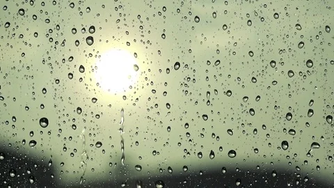 Rain drops fall on the window - sun in the background Stock Footage 79356110