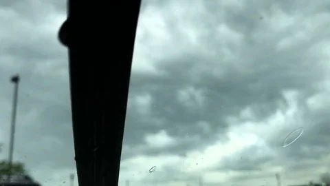 Rain Drops Fall on a Windshield as the Windshield Wipers Swish Back and Forth Stock-Footage 79174239