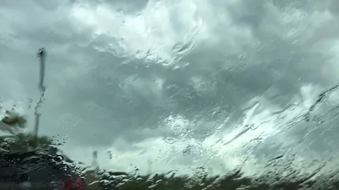 Rain Drops Fall on a Windshield as the Windshield Wipers Swish Back and Forth Stock Footage 79174291