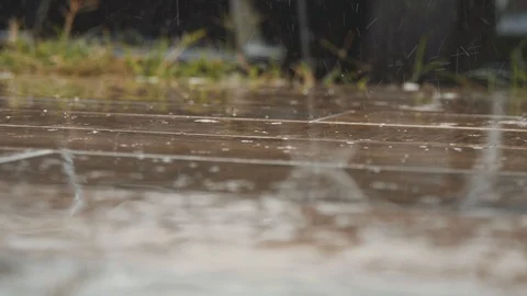 Rain drops fall on the wooden floor. Close up shot of splashes from heavy rain 스톡 동영상 99002805