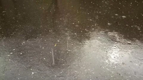 Rain drops falling on asphalt, road with wet surface texture 写真素材