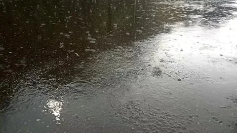 Rain drops falling on asphalt, road with wet surface texture 写真素材