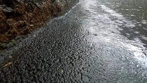 Rain drops falling on asphalt, road with wet surface texture 写真素材