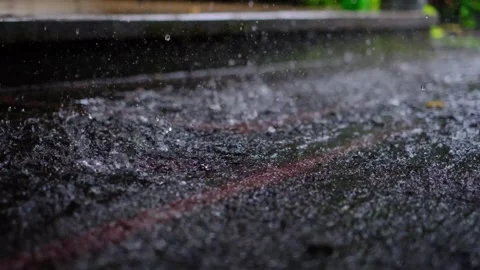 Rain drops falling on asphalt in slow motion loop during a rain storm Stock Footage 262523759