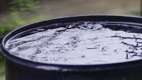 Rain drops falling in barrel splashing, collecting rain water, slow mo Stock Footage 305432959