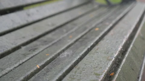 Rain drops falling on a bench in close up view. Stock Footage 160181857