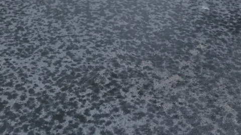 Rain drops falling on black pavement Stockbeeldmateriaal 92588978