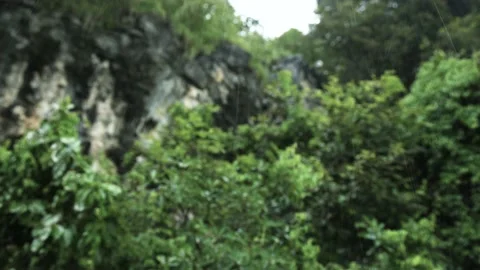 Rain drops falling on a blurred out of focus cliff of mountain Stock Footage 153506784