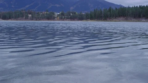 Rain drops falling on calm lake Stock-Footage 127467121