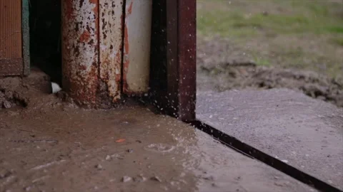 Rain drops falling on concrete in a barn or garage in slow motion Stock Footage 247423547