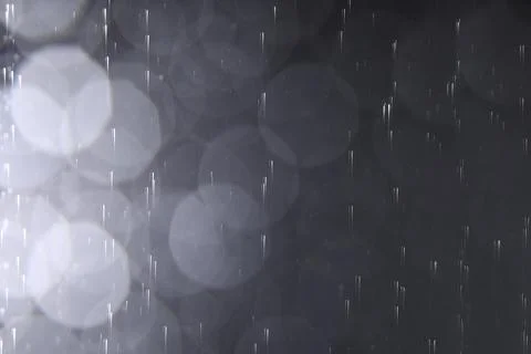 Rain drops falling down against dark background Stock Photos