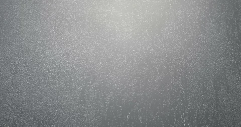 Rain drops falling down on glass grey background, water droplets on window Stock Footage