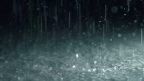 Rain drops falling into ground, slow motion Stock Footage