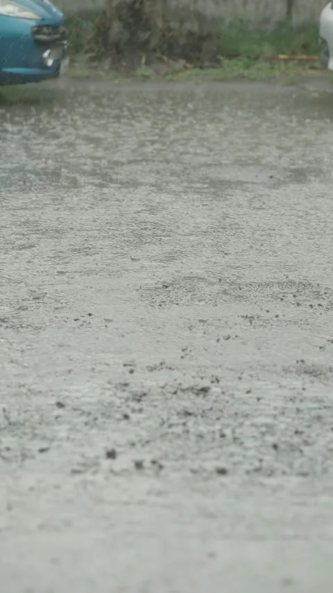 Rain drops falling into a muddy puddle on broken asphalt. Stock Footage 338364341