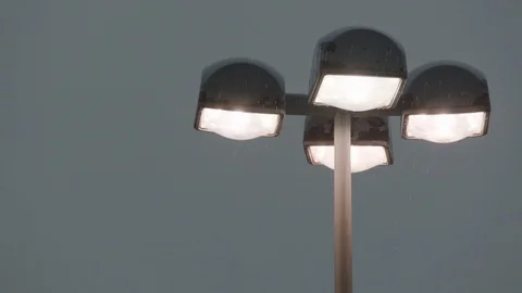 Rain drops falling over illuminated lamp in stadium Stock Footage 105423876