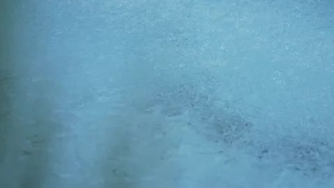 Rain drops falling on a pale blue swimming pool Stock Footage 346090349