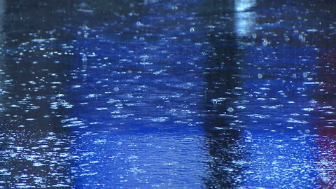 Rain drops falling on pavement asphalt at night Stock Footage 236334119